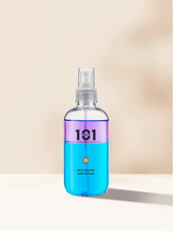 A clear spray bottle filled with blue liquid, labeled Beijing 101 Bio Ceratin Hair Repair, is displayed on a light surface against a soft beige background, showcasing its advanced Bio Ceratin formula for effective hair repair.